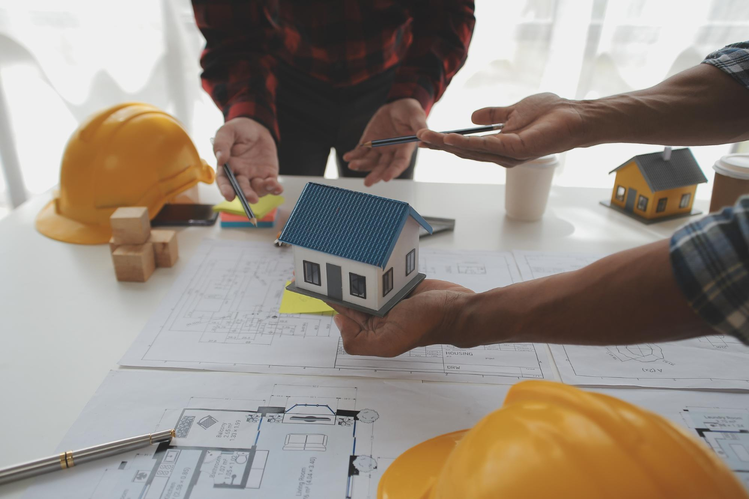 un constructeur de maison prépare les plans avec ses clients